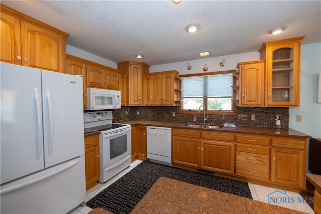 kitchen featuring white appliances, light tile patterned floors, decorative backsplash, and sink