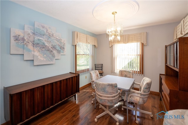 dining area featuring dark hardwood / wood-style flooring and an inviting chandelier