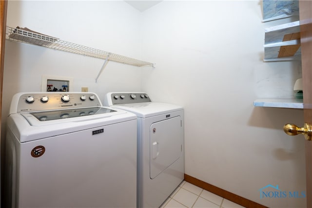 washroom with washer and clothes dryer and light tile patterned floors