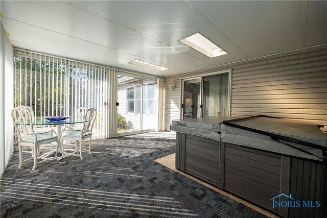 unfurnished sunroom with a jacuzzi and a skylight