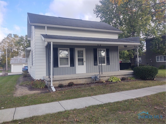 view of front of house with a porch, a front yard, and a garage