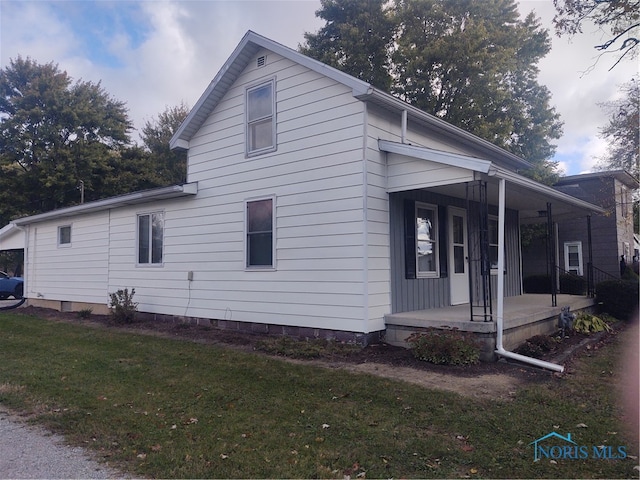 view of home's exterior featuring a yard and covered porch