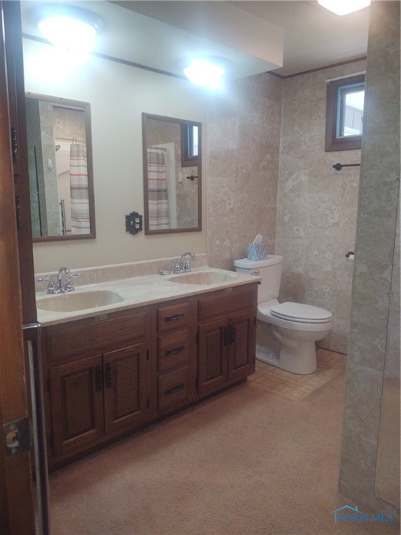 bathroom with curtained shower, vanity, and toilet