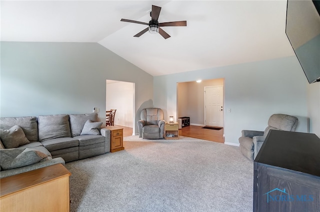 living room with ceiling fan, vaulted ceiling, and light colored carpet