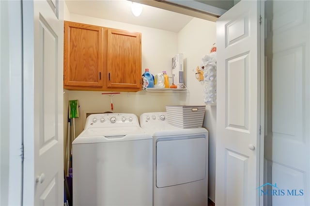 laundry area with washer and clothes dryer and cabinets