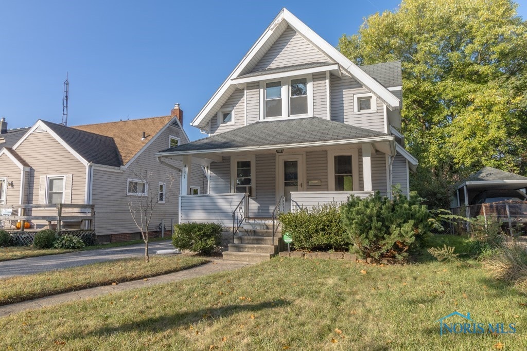 view of front of property featuring covered porch and a front yard