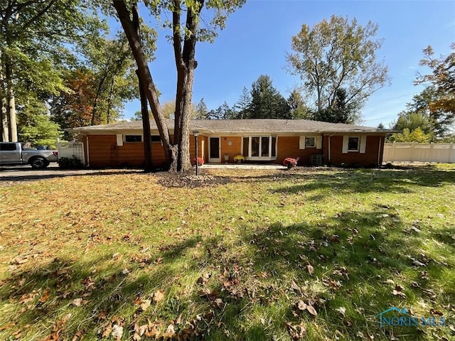 ranch-style home with a front lawn and central AC