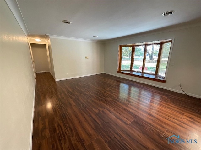 empty room with crown molding and dark hardwood / wood-style flooring