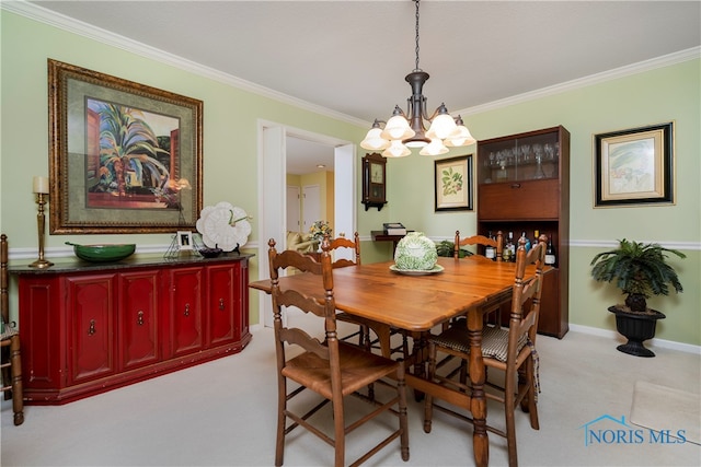 carpeted dining area featuring crown molding and a chandelier