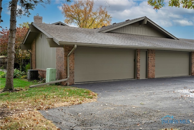 view of side of property featuring cooling unit and a garage