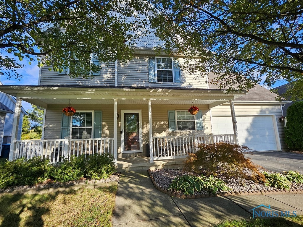 view of front of property featuring covered porch and a garage