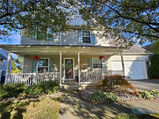 view of front of property featuring covered porch and a garage