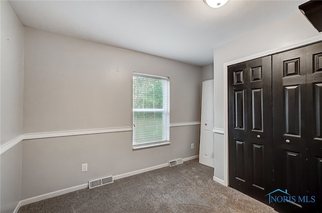 unfurnished bedroom with a closet and carpet