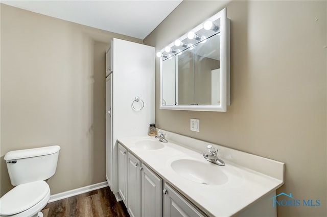 bathroom featuring vanity, hardwood / wood-style flooring, and toilet