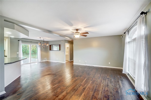 unfurnished living room featuring dark hardwood / wood-style floors and ceiling fan with notable chandelier