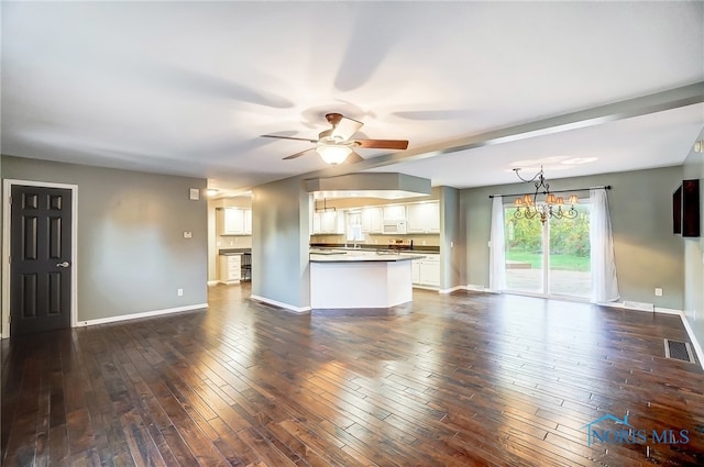 unfurnished living room featuring ceiling fan with notable chandelier and dark hardwood / wood-style floors