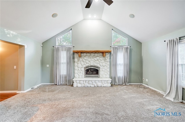 unfurnished living room with carpet flooring, lofted ceiling, plenty of natural light, and a fireplace