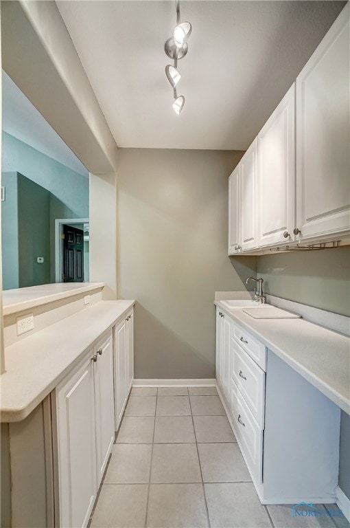 laundry room featuring sink and light tile patterned floors