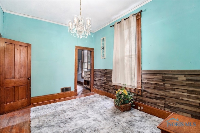 interior space with hardwood / wood-style flooring, crown molding, and a chandelier