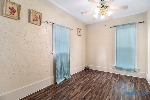 unfurnished room with dark hardwood / wood-style floors and ceiling fan