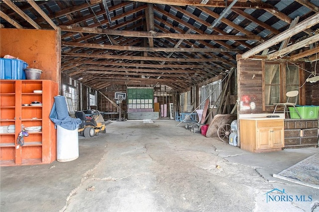 miscellaneous room with concrete flooring and vaulted ceiling