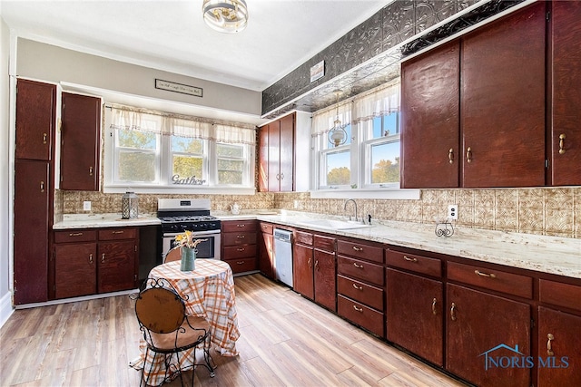 kitchen featuring light hardwood / wood-style floors, sink, light stone countertops, and stainless steel appliances