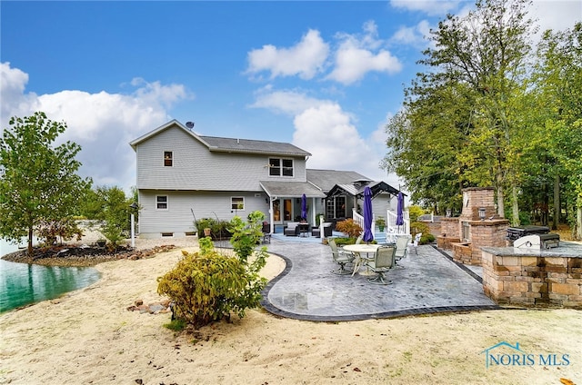 back of house featuring a patio area and a fireplace