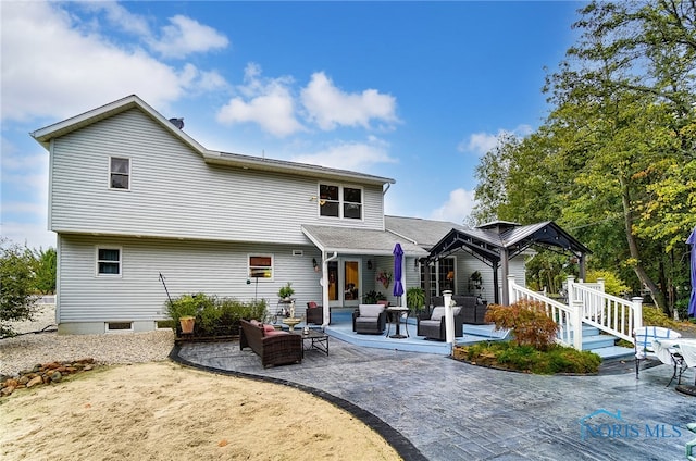 back of house featuring outdoor lounge area and a patio