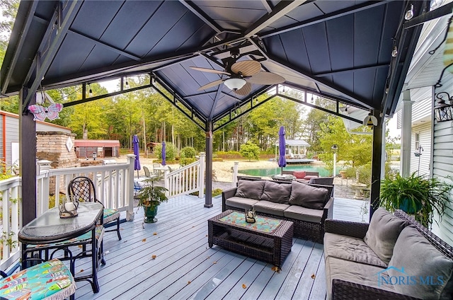 wooden terrace with a gazebo, an outdoor living space, and ceiling fan