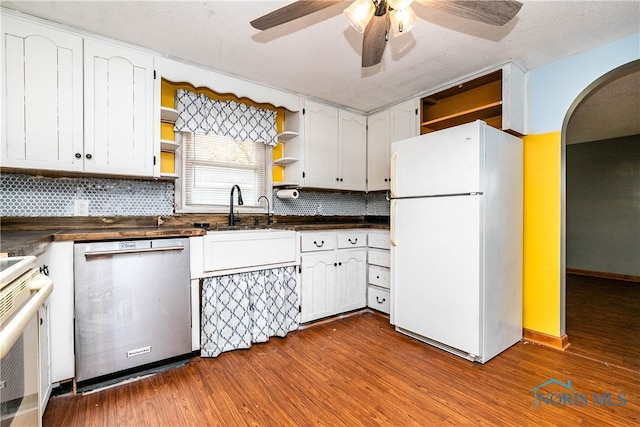 kitchen featuring wood-type flooring, backsplash, stainless steel dishwasher, white cabinets, and white fridge