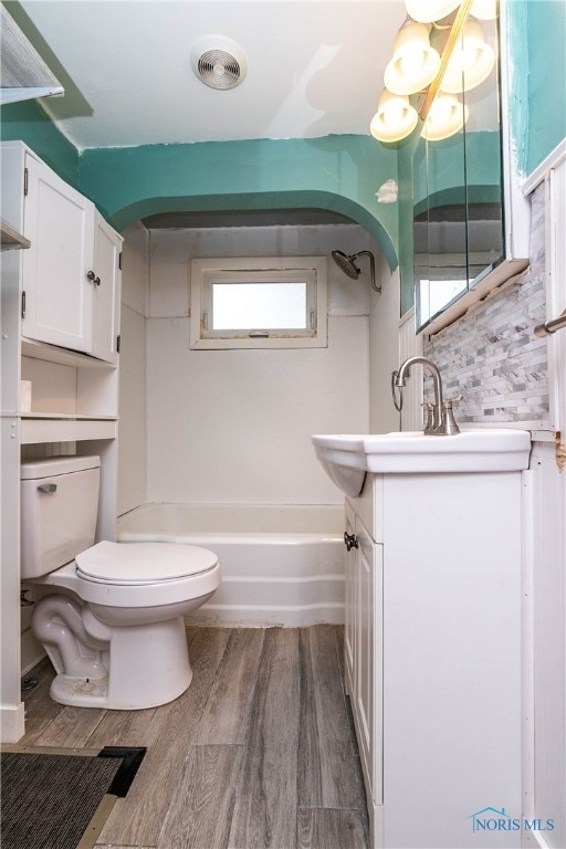 full bathroom featuring vanity, hardwood / wood-style flooring, toilet, and a wealth of natural light