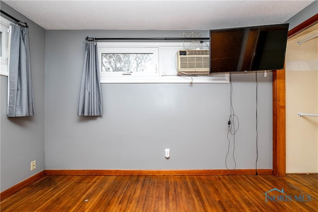 empty room featuring a textured ceiling and hardwood / wood-style flooring