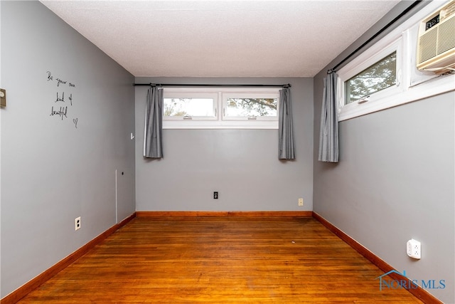 empty room featuring a textured ceiling and wood-type flooring