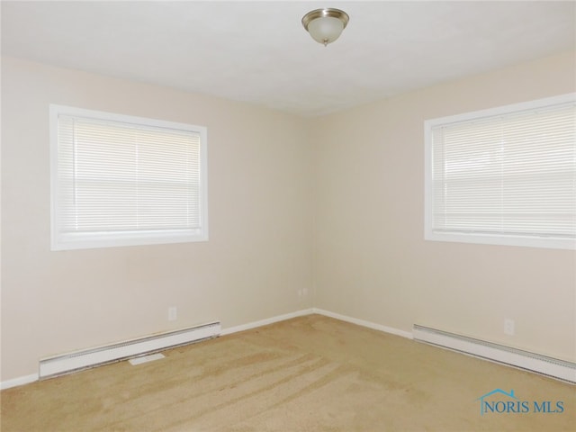 empty room with light colored carpet and a baseboard radiator