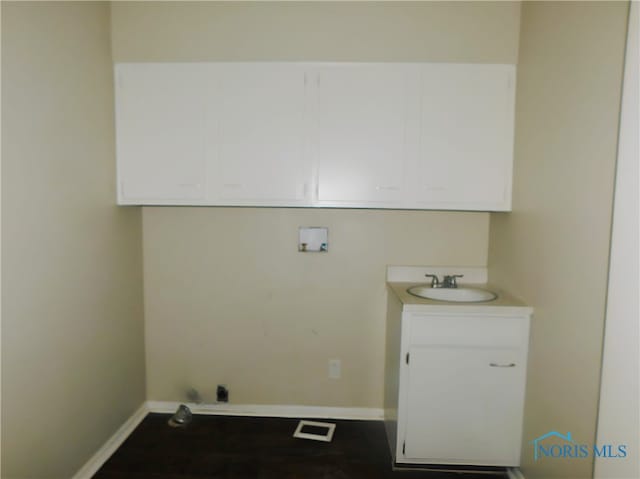 washroom featuring hookup for a washing machine, cabinets, and sink