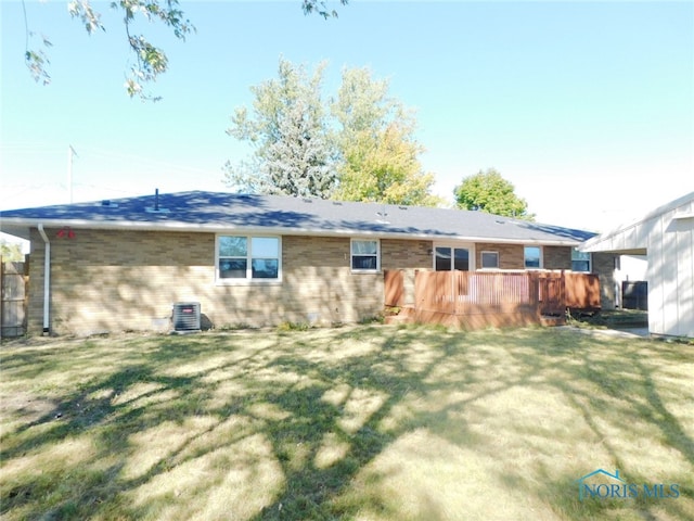 back of property with a deck and a lawn