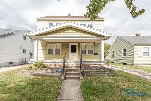 view of front facade featuring covered porch and a front yard