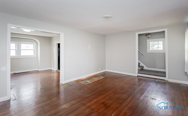 unfurnished room featuring dark wood-type flooring and plenty of natural light