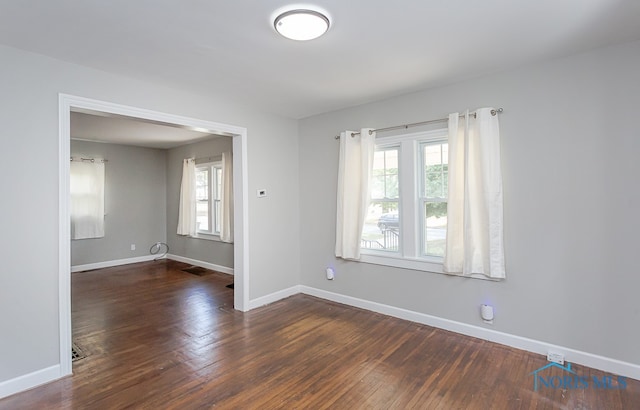 unfurnished room with dark wood-type flooring and a healthy amount of sunlight