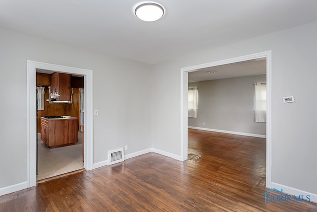 unfurnished room with dark hardwood / wood-style flooring