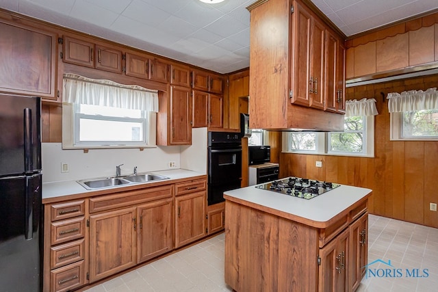 kitchen with a center island, black appliances, sink, and plenty of natural light