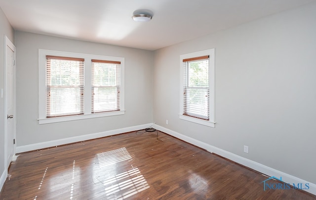 spare room with dark hardwood / wood-style flooring