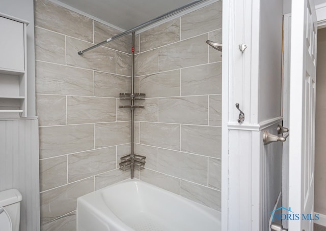 bathroom featuring toilet and tiled shower / bath