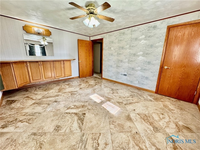 unfurnished bedroom featuring ceiling fan and crown molding