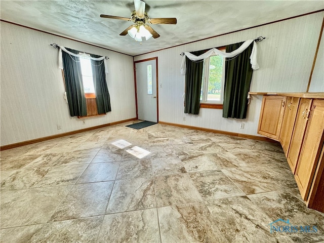 unfurnished room featuring ceiling fan and a wealth of natural light