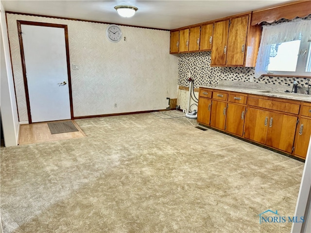 kitchen featuring sink, decorative backsplash, and light colored carpet