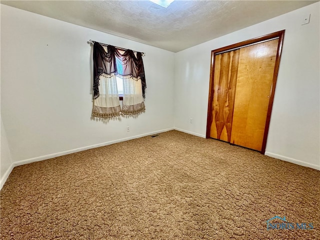 unfurnished bedroom with a closet, carpet, and a textured ceiling