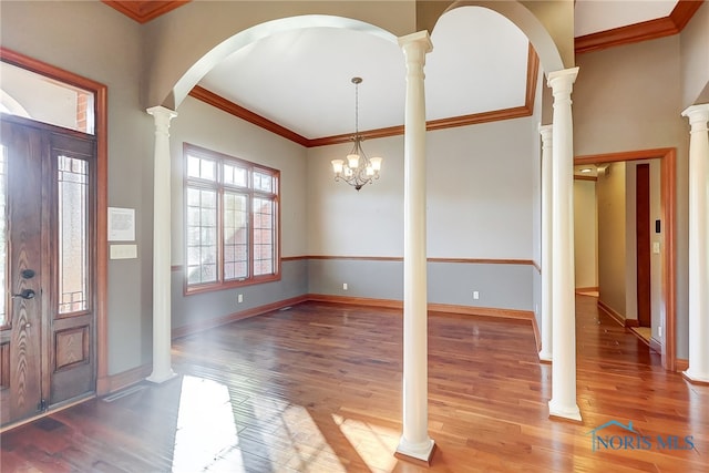 entrance foyer with crown molding, hardwood / wood-style floors, and a chandelier