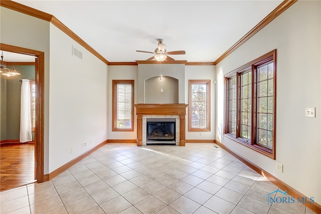 unfurnished living room featuring ornamental molding, light tile patterned floors, a tile fireplace, and ceiling fan