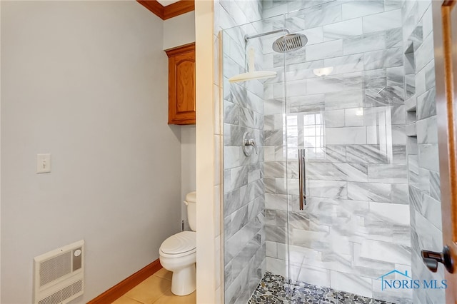 bathroom featuring tiled shower, heating unit, toilet, and tile patterned flooring